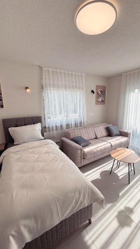 Un dormitorio con una cama grande y un sofá. en Nisay Home, Apart Suite, N4, en Ludwigsburg