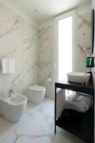 a bathroom with a sink and a toilet and a mirror at Melia Venezia Lido in Venice-Lido