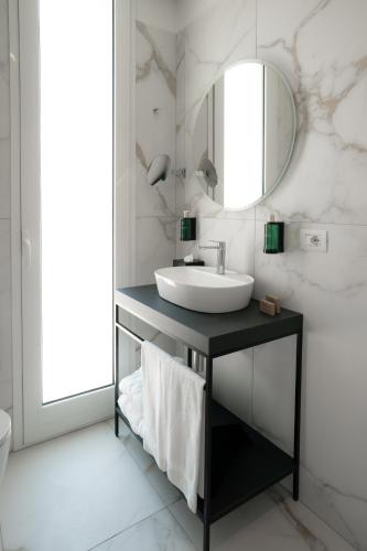 a bathroom with a sink and a mirror at Melia Venezia Lido in Venice-Lido