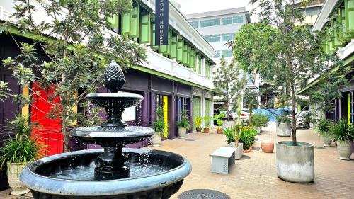 a fountain in the middle of a courtyard with plants at Soho House Old Town Bangkok in Bangkok
