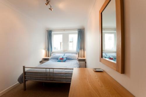 a bedroom with a bed and a mirror at Seaspray in Saint Mawes