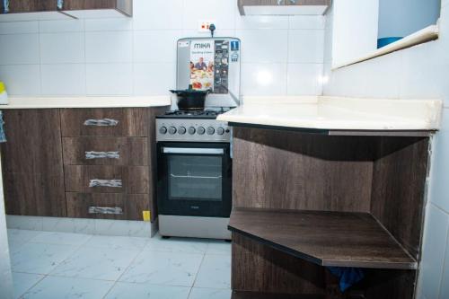 a kitchen with a stove and a white counter top at The African touch in Galu