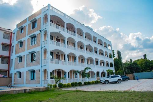 a white building with a car parked in front of it at The African touch in Galu