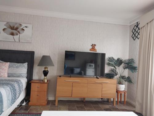a bedroom with a bed and a tv on a dresser at Sweet Home by the Golf Course in Canberra