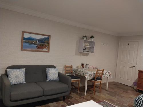 a living room with a couch and a table at Sweet Home by the Golf Course in Canberra