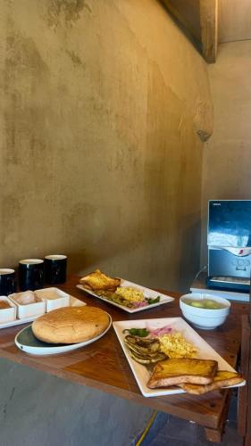 a wooden table with plates of food on it at Escape Retreat Hunza in Karimabad Hunza