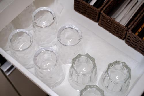 a group of glass cups sitting in a drawer at 夏様楽善 Historic Kyoto Machiya,Experience Japanese Lifestyle Comfortably in Kyoto