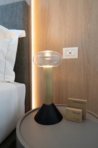 a lamp on a table next to a bed at Melia Venezia Lido in Venice-Lido
