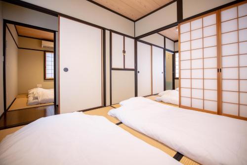 a room with two beds and a mirror at 夏様楽善 Historic Kyoto Machiya,Experience Japanese Lifestyle Comfortably in Kyoto