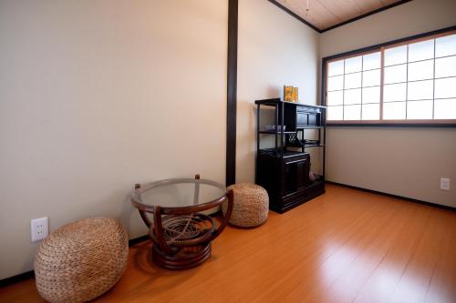 a room with a glass table and two stools at 夏様楽善 Historic Kyoto Machiya,Experience Japanese Lifestyle Comfortably in Kyoto