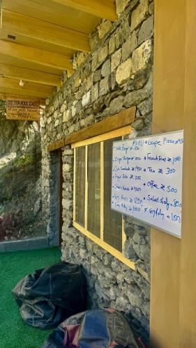 a sign on a stone wall next to a window at Escape Retreat Hunza in Karimabad Hunza