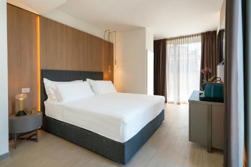 a bedroom with a large bed and a large window at Melia Venezia Lido in Venice-Lido