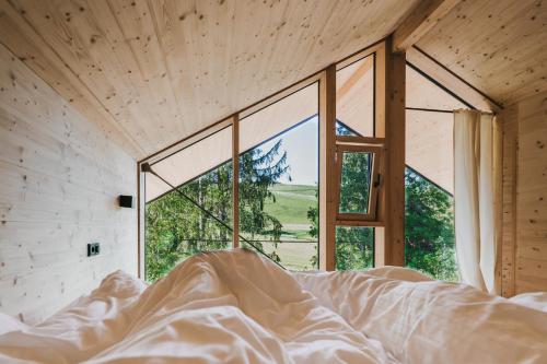 ミッセン・ヴィルハムスにあるBAUMCHALETS Allgäuの大きな窓のある部屋のベッド