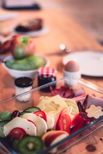 a tray of cheese and fruit on a wooden table at BAUMCHALETS Allgäu in Missen-Wilhams