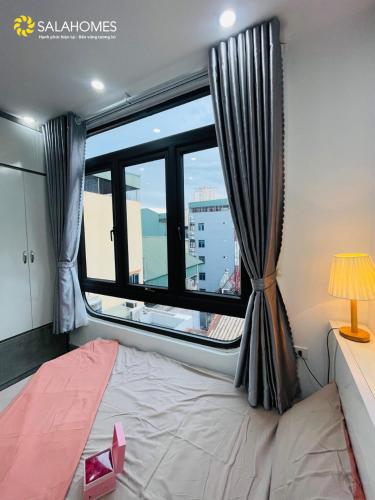 a bedroom with a bed and a large window at Salahomes Apartment by Dapano in Hanoi
