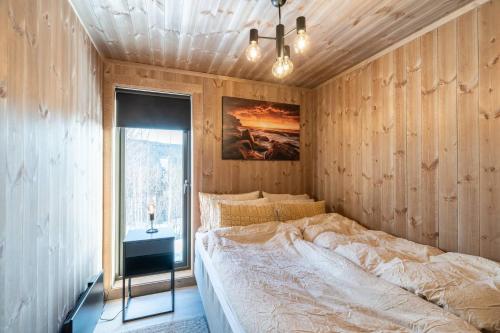 a bedroom with a bed in a wooden wall at Spacious lodge with sauna, ski centre in Noresund