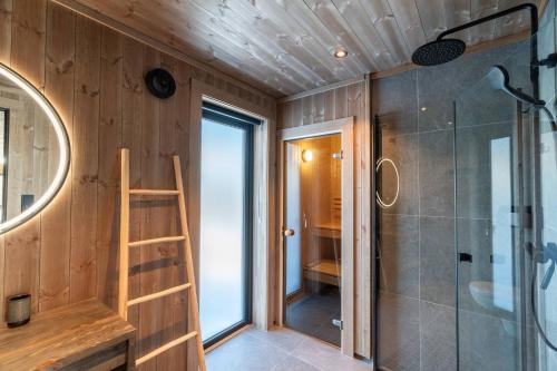 a small bathroom with a shower and a ladder at Spacious lodge with sauna, ski centre in Noresund