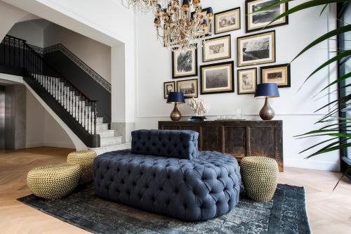 ein Wohnzimmer mit einem blauen Stuhl und einem Kronleuchter in der Unterkunft Hotel Midmost by Majestic Hotel Group in Barcelona