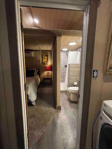 a room with a bedroom and a bed and a bathroom at The Big Tiny White House in Hurricane