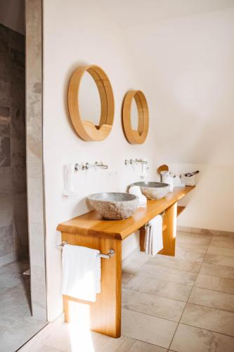 a bathroom with two sinks and two mirrors at Ferienhäuser Hoher Knochen mit Sauna in Schmallenberg