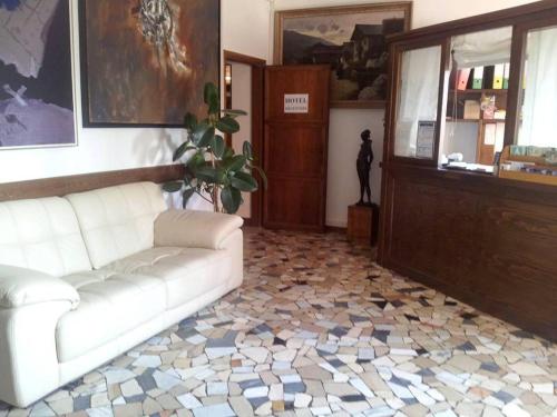 a living room with a white couch and a tile floor at Hotel Piol in Limana