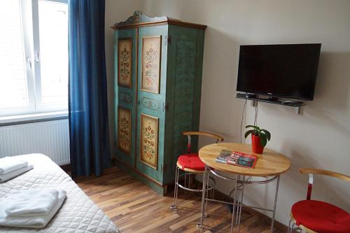 a room with a bed and a table and a tv at Vip Apartment an den Thermen in Baden-Baden
