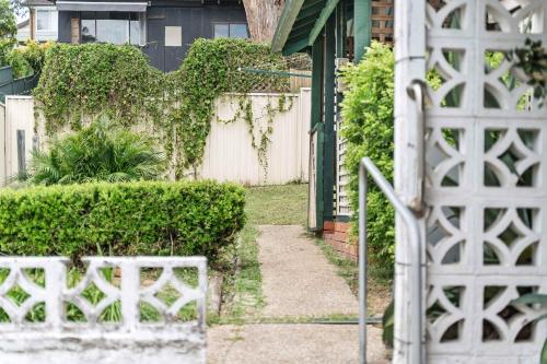 a garden with a white fence and bushes at Simple Single Room - Serene Spot at Peakhurst - Shared Bathroom in Peakhurst