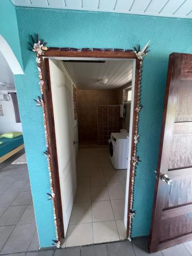 a bathroom with a blue wall and a doorway at Tepuru Lodge in Fakarava