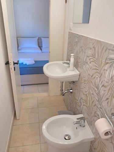 a bathroom with a sink and a toilet and a bed at Villa Noesyr in Neviano