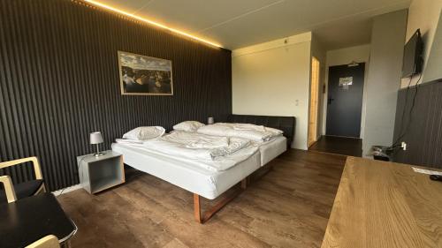 a bedroom with a white bed in a room at Løgstør Parkhotel in Løgstør
