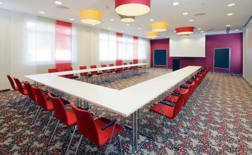 a conference room with a long table and red chairs at Hotel Löwengarten in Speyer