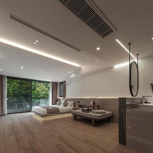 a bedroom with a bed and a sink in a room at Anji Xishan Linyu Chinese-style Spring · Stream Tracing · Vacation Boutique Inn in Anji