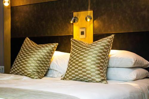 a bed with two pillows on top of it at Happy Valley Hotel and Casino in Ezulwini