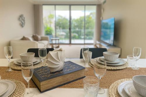 a dining room table with plates and glasses on it at 3BR retreat at South Bank near the beach! in Brisbane