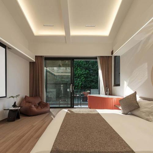 a bedroom with a large bed and a bathroom at Anji Xishan Linyu Chinese-style Spring · Stream Tracing · Vacation Boutique Inn in Anji