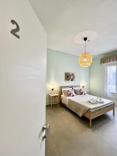 a bedroom with a bed and a chandelier at a casa rà Palumma Rooms in Avola