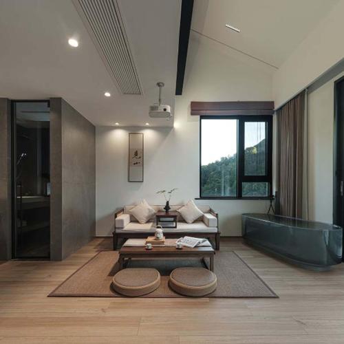 a living room with a tub and a couch and a table at Anji Xishan Linyu Chinese-style Spring · Stream Tracing · Vacation Boutique Inn in Anji