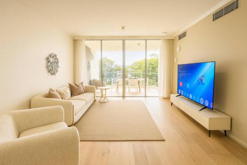 a living room with a couch and a flat screen tv at 3BR retreat at South Bank near the beach! in Brisbane