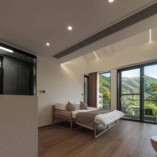 a bedroom with a bed and a large window at Anji Xishan Linyu Chinese-style Spring · Stream Tracing · Vacation Boutique Inn in Anji