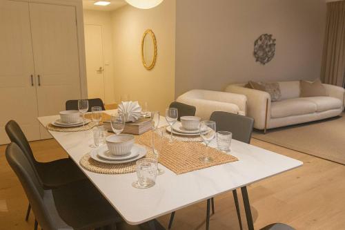 a dining room with a white table and chairs at 3BR retreat at South Bank near the beach! in Brisbane