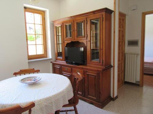 a room with a table and a tv and a cabinet at Casa Elisa in Stresa