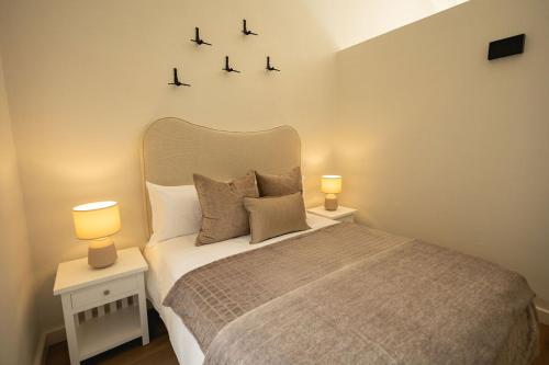 a bedroom with a bed with two lights on the wall at Two Horizons Apartment 6 in Hermanus