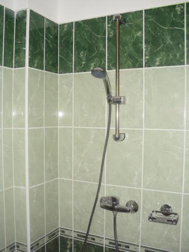a bathroom with a shower with green tiles at Stop Panzio in Debrecen