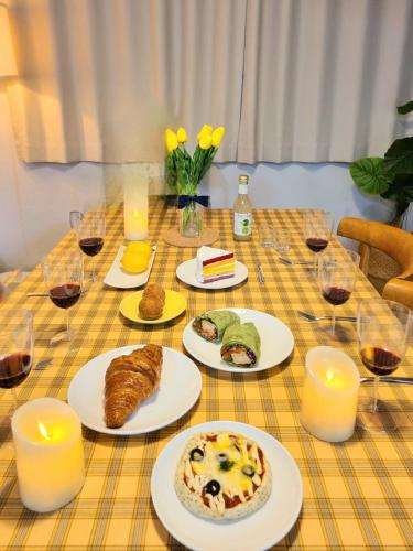 a table with plates of food and glasses of wine at Ye-stay in Daegu