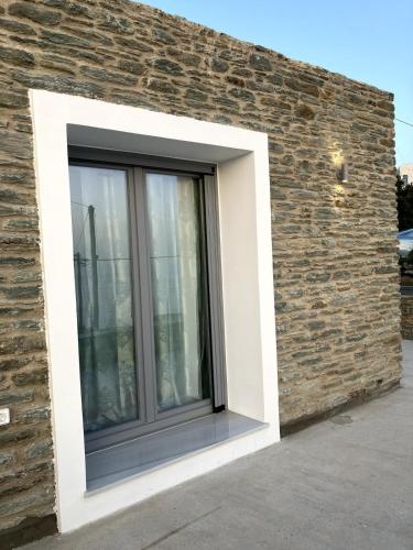 a window on the side of a brick wall at Endless Bleu Villa Andros Island in Apróvaton