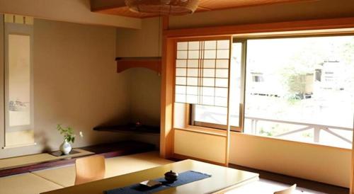 a living room with a large window and a table at Myoken Ishiharaso in Kirishima