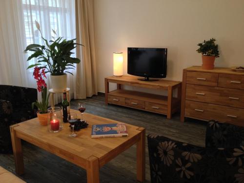 sala de estar con mesa y TV en Apartmenthaus Feuerbach, en Leipzig