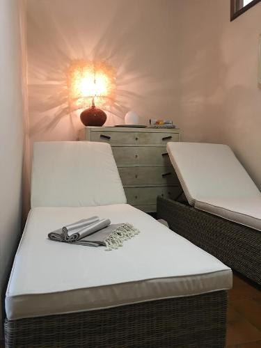 2 Betten in einem Zimmer mit einer Lampe an der Wand in der Unterkunft Il Girasole in Marti