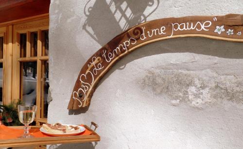 a sign on the side of a building with a plate of food at B&B Le Temps d'une Pause in Champorcher