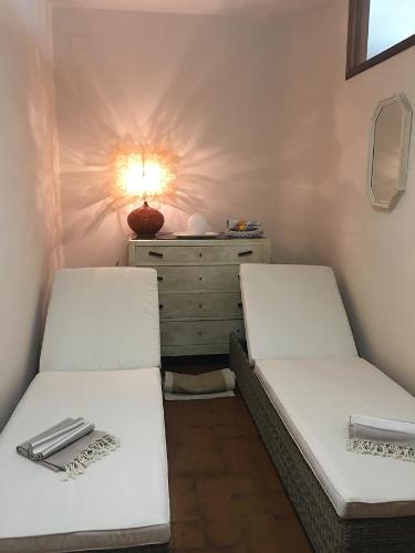 two beds in a room with a dresser and a lamp at Il Girasole in Marti